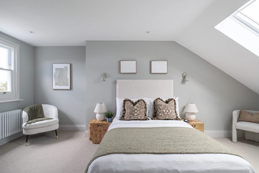 Loft bedroom with recessed downlights and wall lights above the headboard